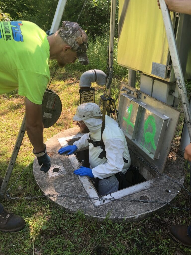 A Biros Septic technician enters a confined-entry space to begin the clean-out process.